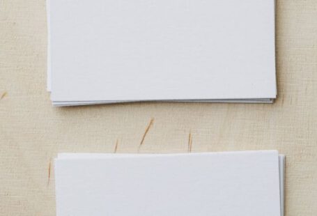 Brand Message - Top view of stacks of white mockup greeting cards placed on light wooden desk in soft daylight